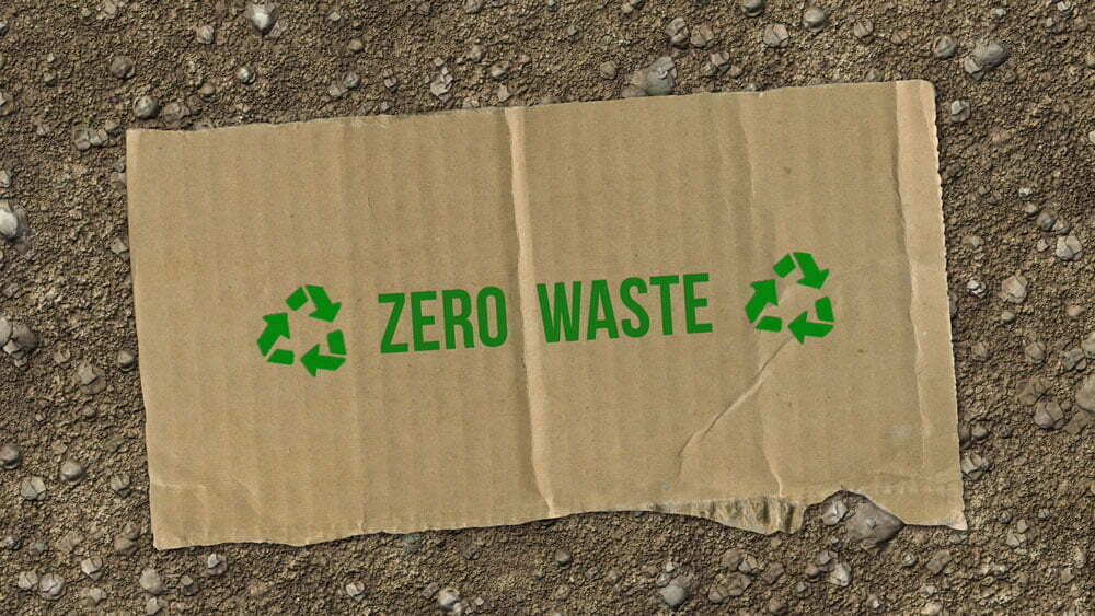 A picture of a piece of cardbpard with a green recycling logo and zero waste text on it