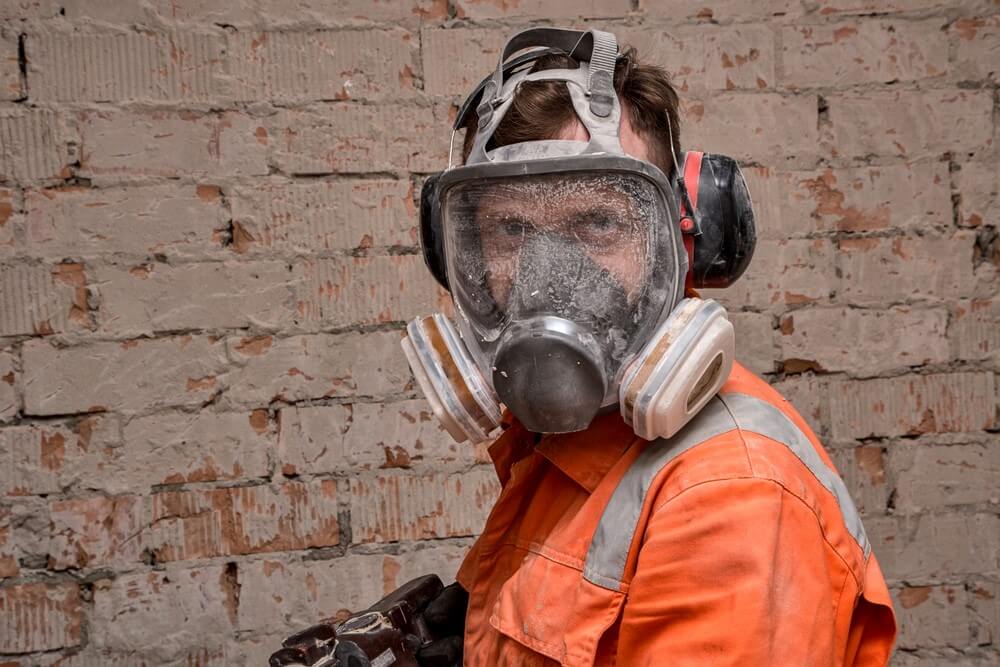 worker cleaning dust while wearing mask
